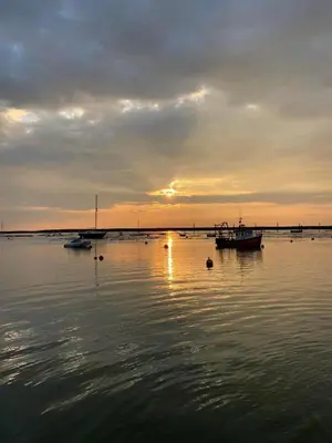 a group of boats in the water at sunset at The Nutshell in West Mersea