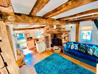 a living room with a blue couch and a fireplace at The Nutshell in West Mersea
