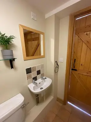 a bathroom with a sink and a toilet and a mirror at Pretty Cottage In Charming Peaceful Village - Easy Commute to Cambridge - Cambridge Homehost in Cambridge