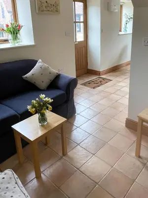 a living room with a blue couch and a table at Pretty Cottage In Charming Peaceful Village - Easy Commute to Cambridge - Cambridge Homehost in Cambridge