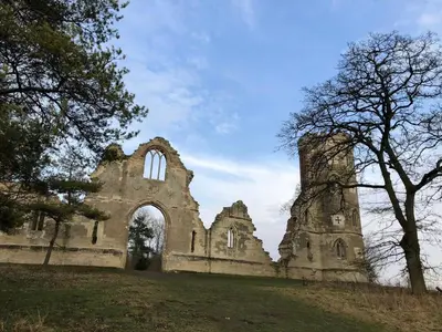 an old stone building with an arch in a field at Pretty Cottage In Charming Peaceful Village - Easy Commute to Cambridge - Cambridge Homehost in Cambridge