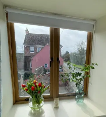 a window with flowers in vases on a window sill at Pretty Cottage in peaceful village location close To Cambridge in Cambridge
