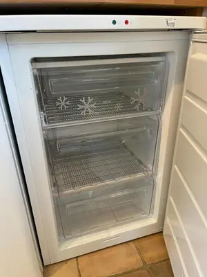 an empty refrigerator door is open in a kitchen at Pretty Cottage in peaceful village location close To Cambridge in Cambridge