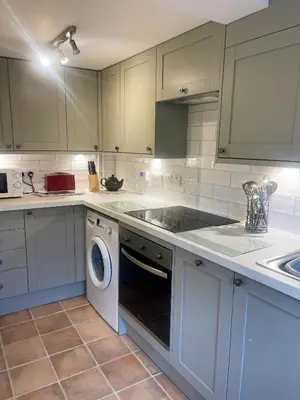 a kitchen with a sink and a washing machine at Pretty Cottage in peaceful village location close To Cambridge in Cambridge