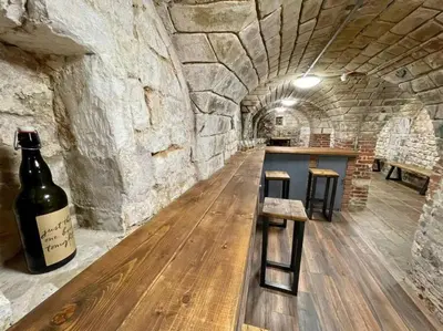 a wine cellar with a table and a bottle of wine at Lydney House Hotel Swaffham Sleeps 22 in Swaffham