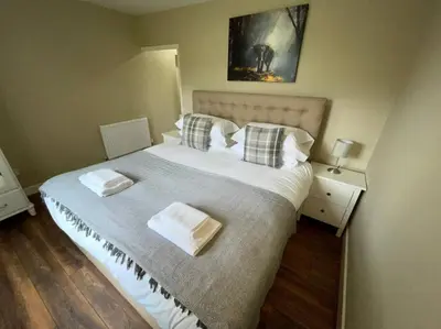 a bedroom with a large bed with two towels on it at Lydney House Hotel Swaffham Sleeps 22 in Swaffham