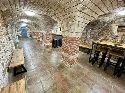 a room with a stone building with tables and benches at Lydney House Hotel Swaffham Sleeps 22 in Swaffham
