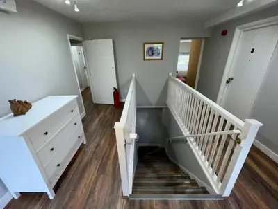 a room with a staircase with a white stair case at Lydney House Hotel Swaffham Sleeps 22 in Swaffham