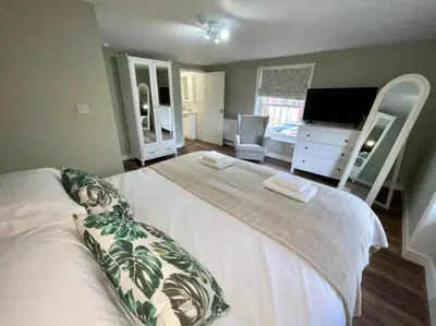 a bedroom with a large white bed and a mirror at Lydney House Hotel Swaffham Sleeps 22 in Swaffham
