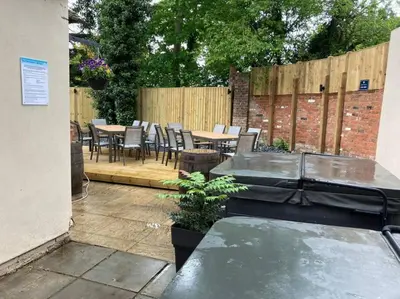 a patio with tables and chairs and a fence at Lydney House Hotel Swaffham Sleeps 22 in Swaffham