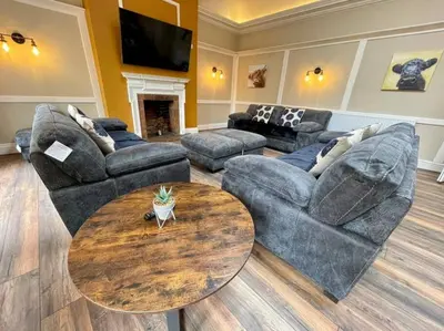a living room with couches and a coffee table at Lydney House Hotel Swaffham Sleeps 22 in Swaffham