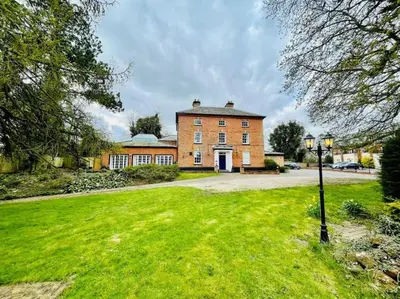 a large brick house with a green lawn in front of it at Lydney House Hotel Swaffham Sleeps 22 in Swaffham
