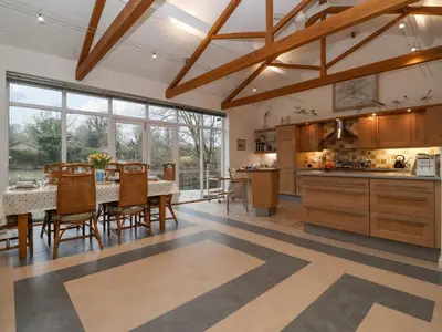 a kitchen with a table and chairs and a large window at Valley Farm Cottage in Woodbridge
