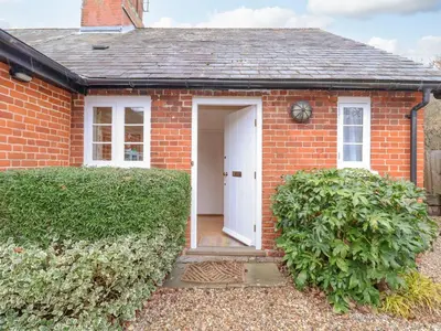 a red brick house with a white door at Valley Farm Cottage in Woodbridge