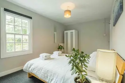 a bedroom with a white bed and a window at Cambridge 3 bedroom flat with private parking in Cambridge
