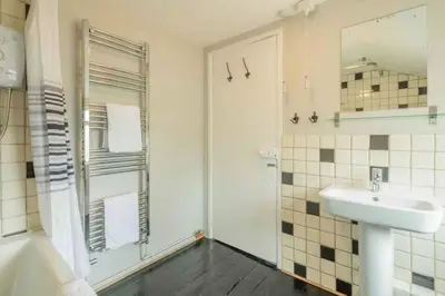 a white bathroom with a sink and a shower at Cambridge 3 bedroom flat with private parking in Cambridge