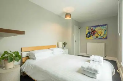 a bedroom with a white bed with towels on it at Cambridge 3 bedroom flat with private parking in Cambridge