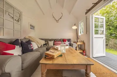 a living room with a couch and a table at Well Green Cottage in Wenhaston