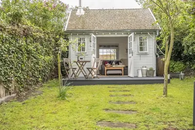 a white cottage with a patio in a yard at Well Green Cottage in Wenhaston