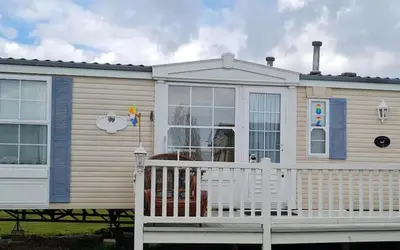 a mobile home with a porch and a white fence at Freedom House in Clacton-on-Sea
