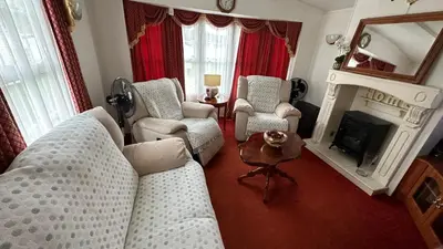 a living room with a couch and chairs and a fireplace at Freedom House in Clacton-on-Sea