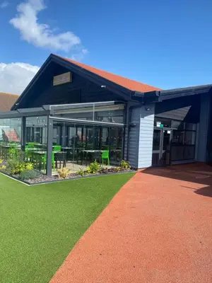 a building with a green lawn in front of it at Stylish 3 Bedroom caravan near the Beach in Walton-on-the-Naze