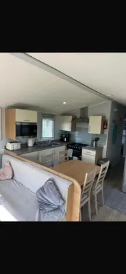 a kitchen and dining room with a table and chairs at Stylish 3 Bedroom caravan near the Beach in Walton-on-the-Naze