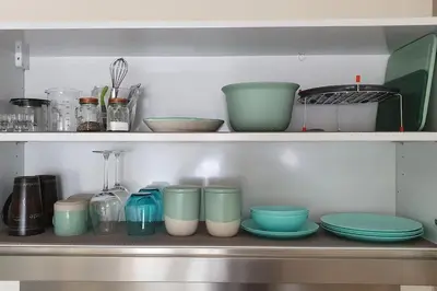 a shelf with bowls and other dishes on it at Self-contained annex with private entrance, double bed, kitchen, bathroom, free car park - Near Cambridge, Duxford Air Museum and Addenbrooke's Hospital in Cambridge