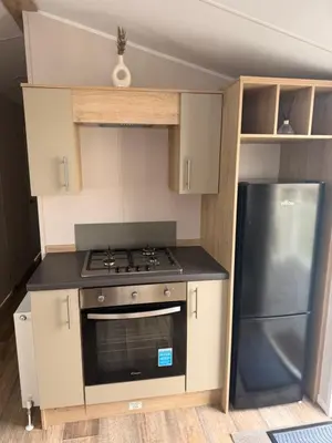 a small kitchen with a stove and a refrigerator at Serenity Holiday Home in Saint Osyth
