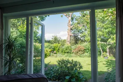 a sliding glass door looking out at a garden at Luxury Self-Catering and Sauna - Oaks Rest in Colchester