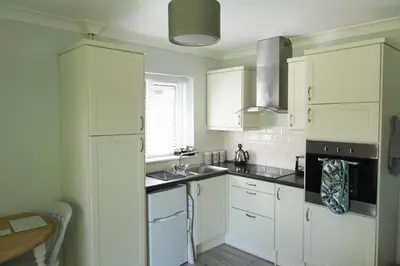 a kitchen with white cabinets and a sink at Luxury Self-Catering and Sauna - Oaks Rest in Colchester