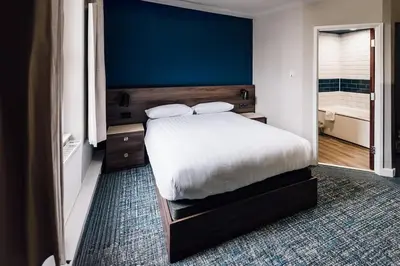 a bedroom with a bed and a blue wall at Downing College in Cambridge