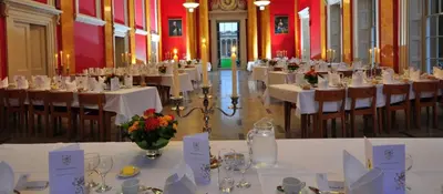 a room filled with tables and chairs with white table cloth at Downing College in Cambridge