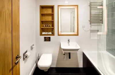 a bathroom with a sink and a toilet and a tub at Downing College in Cambridge
