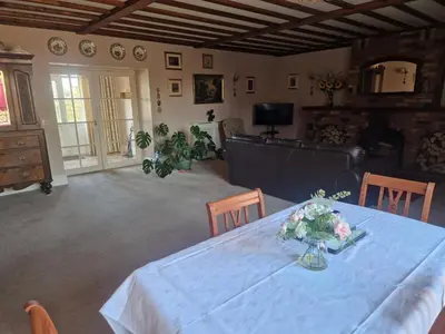 a dining room with a table with a vase of flowers on it at Primroses, Wood Farm in Shipdham