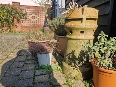 an old bird bath sitting next to some potted plants at Primroses, Wood Farm in Shipdham