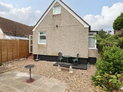 a garden with two chairs and a table in front of a house at 21 Crossways in Clacton-on-Sea