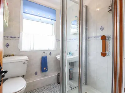 a bathroom with a shower and a toilet and a sink at 21 Crossways in Clacton-on-Sea