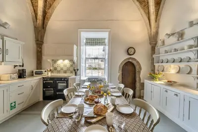a kitchen with a long table and chairs in a room at Butley Priory in Woodbridge