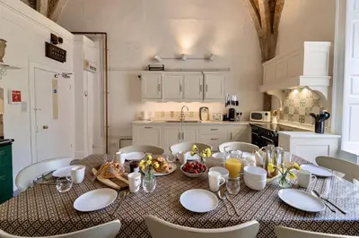 a dining room with a table and chairs in a kitchen at Butley Priory in Woodbridge
