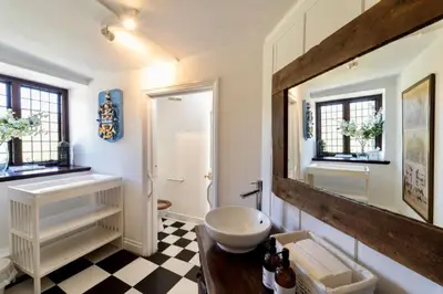 a bathroom with a sink and a mirror at Butley Priory in Woodbridge