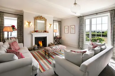 a living room with two couches and a fireplace at Butley Priory Farmhouse in Woodbridge