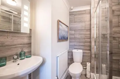 a bathroom with a toilet and a sink and a shower at Villa Verde in Aldeburgh