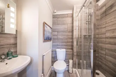a bathroom with a toilet and a glass shower at Villa Verde in Aldeburgh