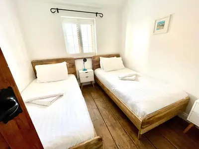 two beds in a small room with a window at The Cart Lodge at Lee Wick Farm Cottages & Glamping in Saint Osyth