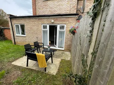 a patio with chairs and a table in front of a building at One Bed Apartment Stevenage in Stevenage