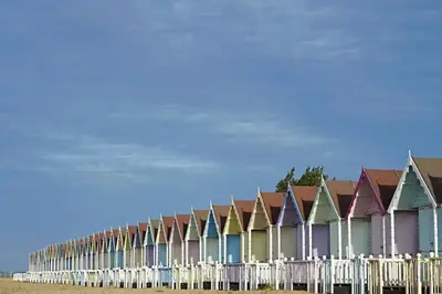a row of colorful houses on the beach at Lighthouse Holiday Retreat in West Mersea