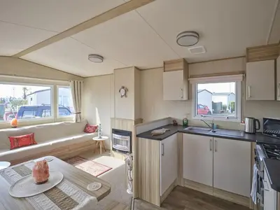 a kitchen and living room with a couch at Lighthouse Holiday Retreat in West Mersea