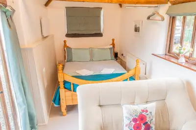 a small bedroom with a bed and a couch at The Retreat in Tibenham