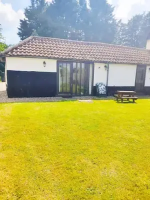a house with a bench in a yard at The Retreat in Tibenham